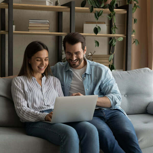 Happy couple searching online for mortgage deals and information about credit scores